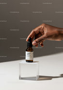 Person Holding Dropper Bottle of Medicine with Minimalist Background