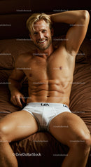 Smiling fit man relaxing on brown bed in white briefs