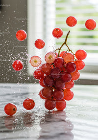Dynamic splash of fresh red grapes bursting with juice