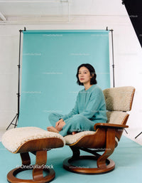 Calm woman seated barefoot on cozy lounge chair