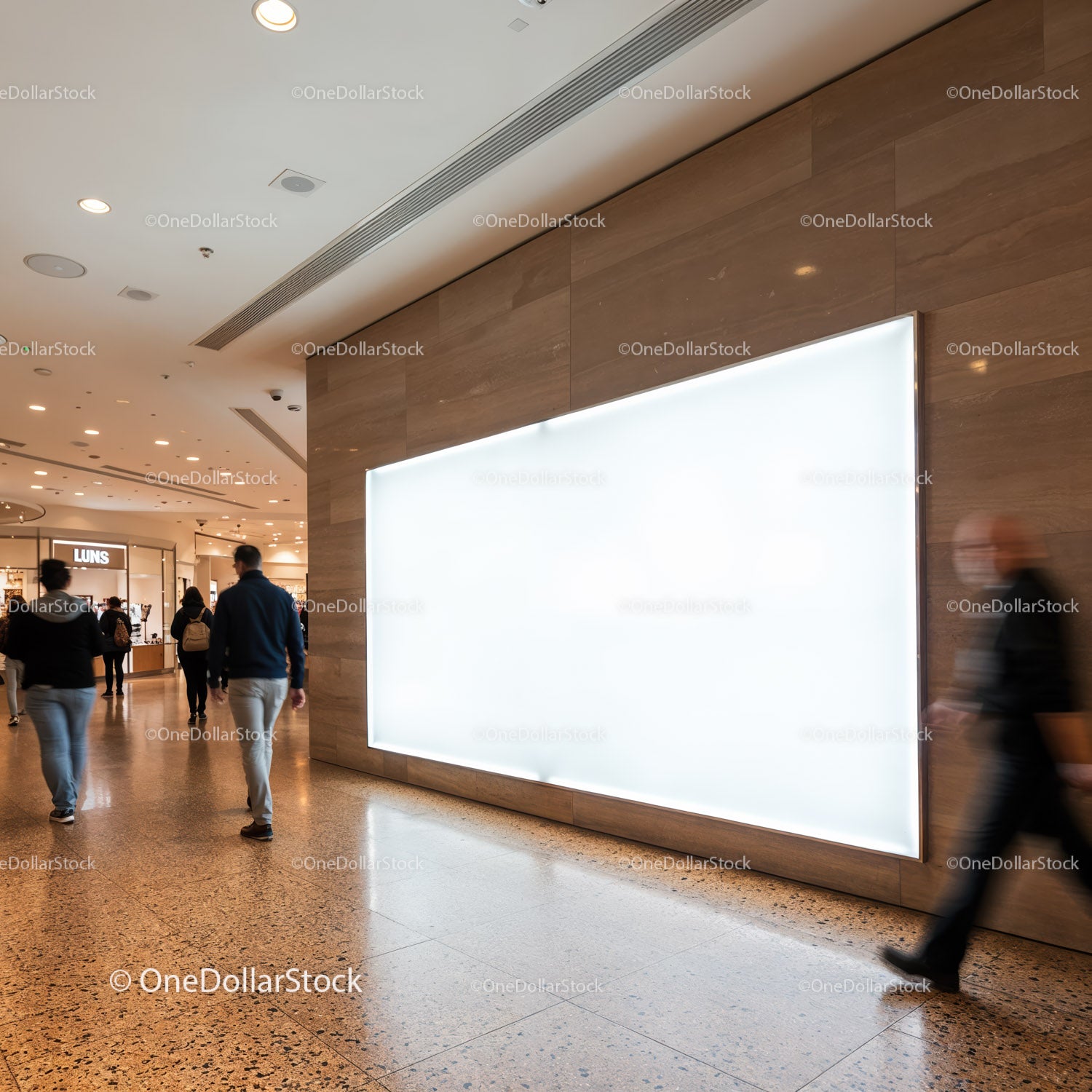 People walking past large illuminated blank billboard indoors