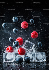 Fresh raspberries and blueberries with ice cubes splash
