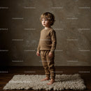 Young toddler boy standing barefoot on cozy rug indoors
