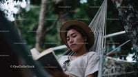 Women Relaxing in Hammock Reading Book in Green Nature Scene