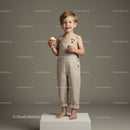 Happy boy standing barefoot with cupcake in studio