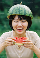 Young woman enjoying fresh watermelon with playful helmet
