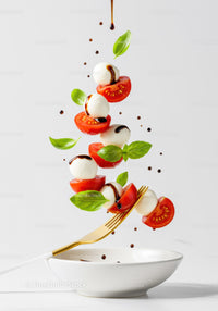 Fresh Caprese Salad Ingredients Falling on White Plate
