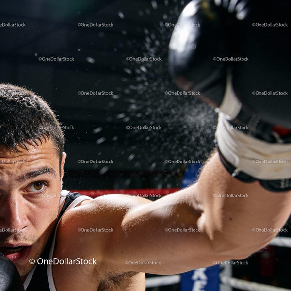 Focused young boxer throwing a powerful punch