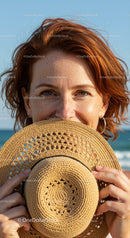 Woman with Red Hair Holding Straw Hat at Sunny Beach with Sea View