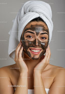 Young Woman Applying Black Facial Mask with Towel Turban