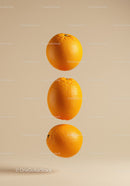 Three floating fresh oranges on beige background