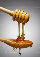 Honey Drizzling from Wooden Stick onto Spoon