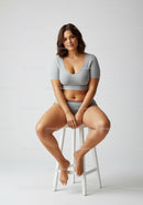 Young Woman Sitting on Stool in Casual Outfit for Modern Lifestyle Stock Photo