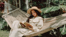 Relaxing Woman Reading Book in Hammock Surrounded by Tropical Greenery