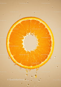 Fresh orange slice dripping juice in soft light