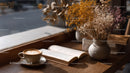 Dried Flowers in Amber Jar with Coffee and Open Book