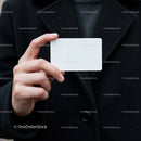 Person Holding Blank White Card in Black Coat