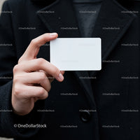 Person Holding Blank White Card in Black Coat