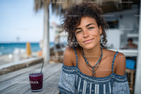 Young Woman Smiling at Seaside Cafe with Drink in Summer