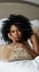 Relaxed woman lying on bed with curly hair and soft pillow