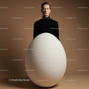 Calm man standing behind giant white egg on brown background