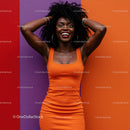 Vibrant Woman in Orange Dress Smiling Against Colorful Wall