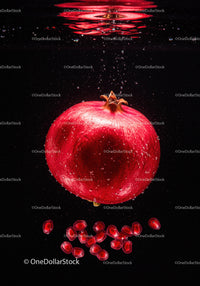 Fresh pomegranate with juicy seeds underwater splash
