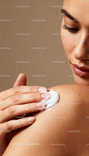 Closeup of woman applying moisturizer on shoulder