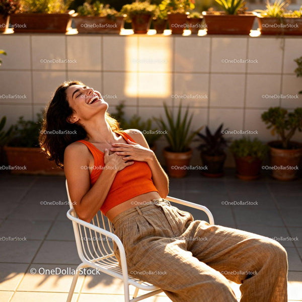 Happy young woman laughing outdoors in warm sunlight