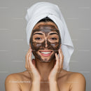 Young Woman with Facial Clay Mask in Spa or Home Setting