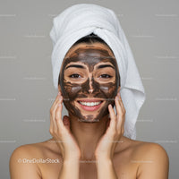 Young Woman with Facial Clay Mask in Spa or Home Setting