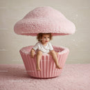 Curly Child Sitting Inside Giant Pink Cupcake