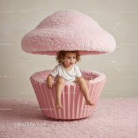 Curly Child Sitting Inside Giant Pink Cupcake