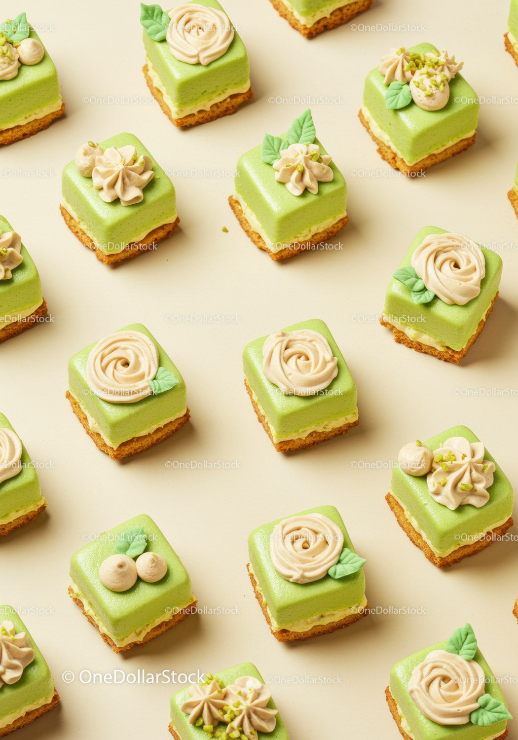 Petit fours z zielonym musem i kremową dekoracją