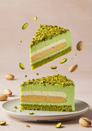 Slice of layered pistachio mousse cake with nuts