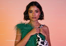 Stylish Woman with Cow Print Dress and Green Feathered Accent in Studio