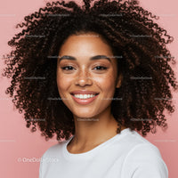 Young woman with curly hair smiling portrait on pink background