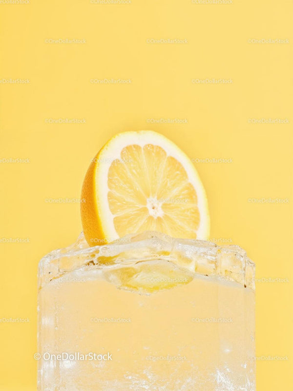 Refreshing lemon slice on ice cube with yellow background