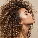 Profile of woman with voluminous curly highlighted hair