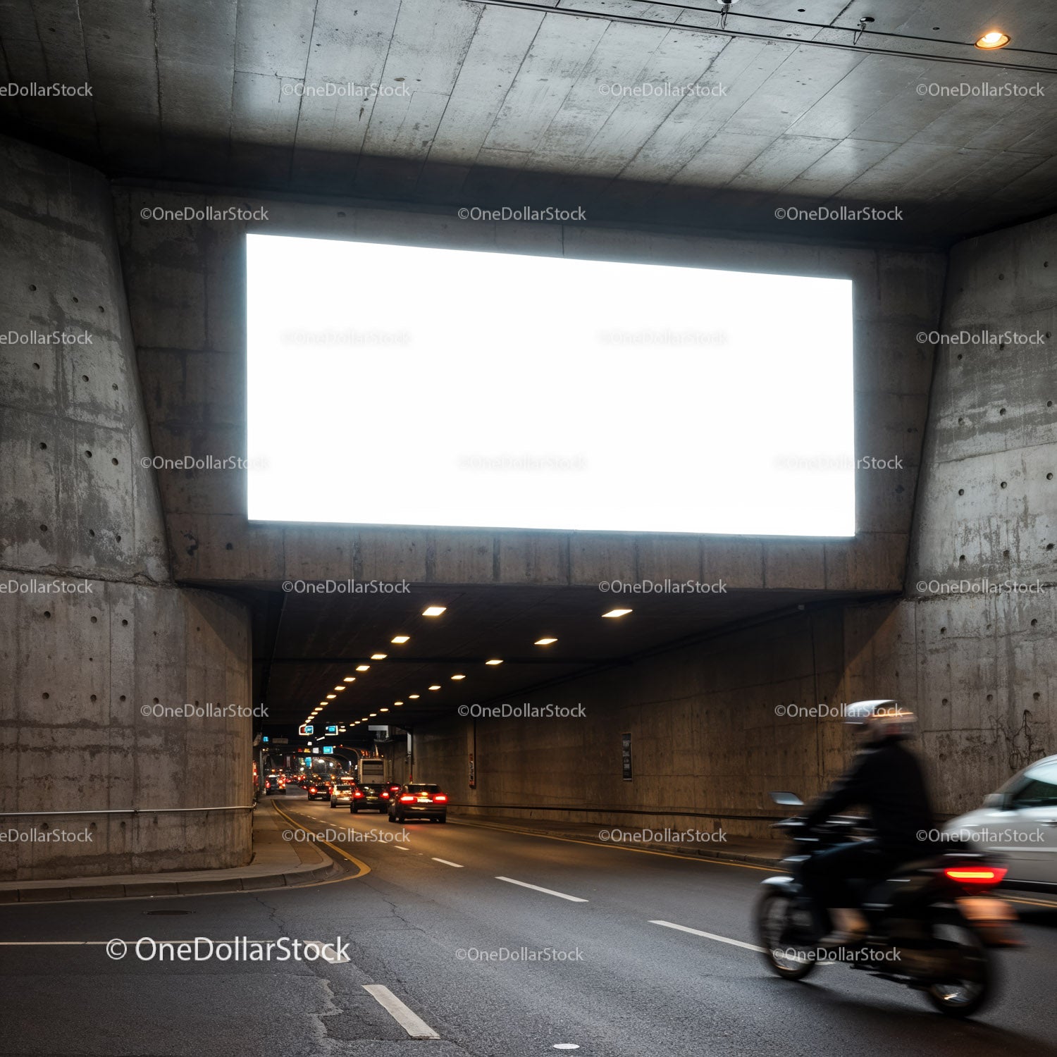 Motocyklista jadący miejskim tunelem o zmierzchu