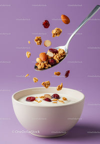 Healthy granola and nuts falling into white bowl