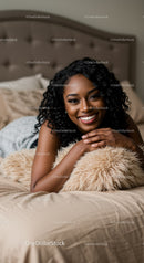 Smiling woman relaxing on bed with cozy pillow