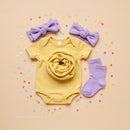 Yellow Baby Bodysuit Set with Purple Accessories and Confetti