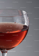 Close up of a glass with rosé wine droplets