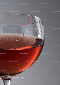 Close up of a glass with rosé wine droplets