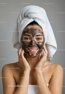 Woman Applying Facial Mask with Towel Wrapped Head in Spa Setting