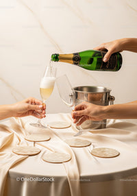 Celebratory Champagne Pour in Elegant Setting with Glasses and Coasters