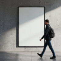 Man walking past blank poster on concrete wall