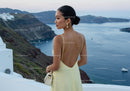 Woman in Yellow Dress Overlooking Coastal Cliffs at Dusk