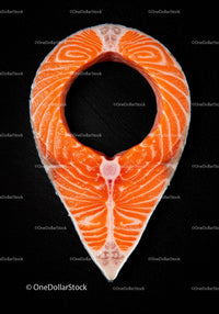 Raw salmon steak shaped like location pin on black background